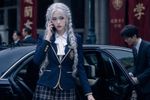 k-pop music video screencap. A girl steps out of a car. She is breathtaking and terrifying. She carries herself with a regal imperiousness that makes the adults around her seem like servants. She wears the uniform of Seiran Girls' Academy—a navy blue blazer with gold piping, a plaid skirt, and a white silk ribbon. The blazer is tailored perfectly to her frame. Her hair is a cascade of silver-white, styled in intricate twin braids that drape over her shoulders. Her eyes are a piercing, analytical violet, scanning the street as if checking for dust bunnies—or assassins. She holds a smartphone to her ear, her expression bored and disdainful.
